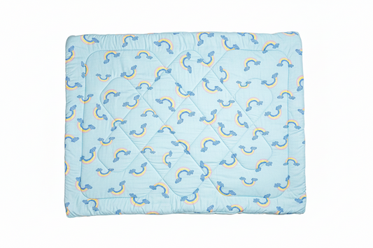 Blue quilt with rainbow pattern on a white background
